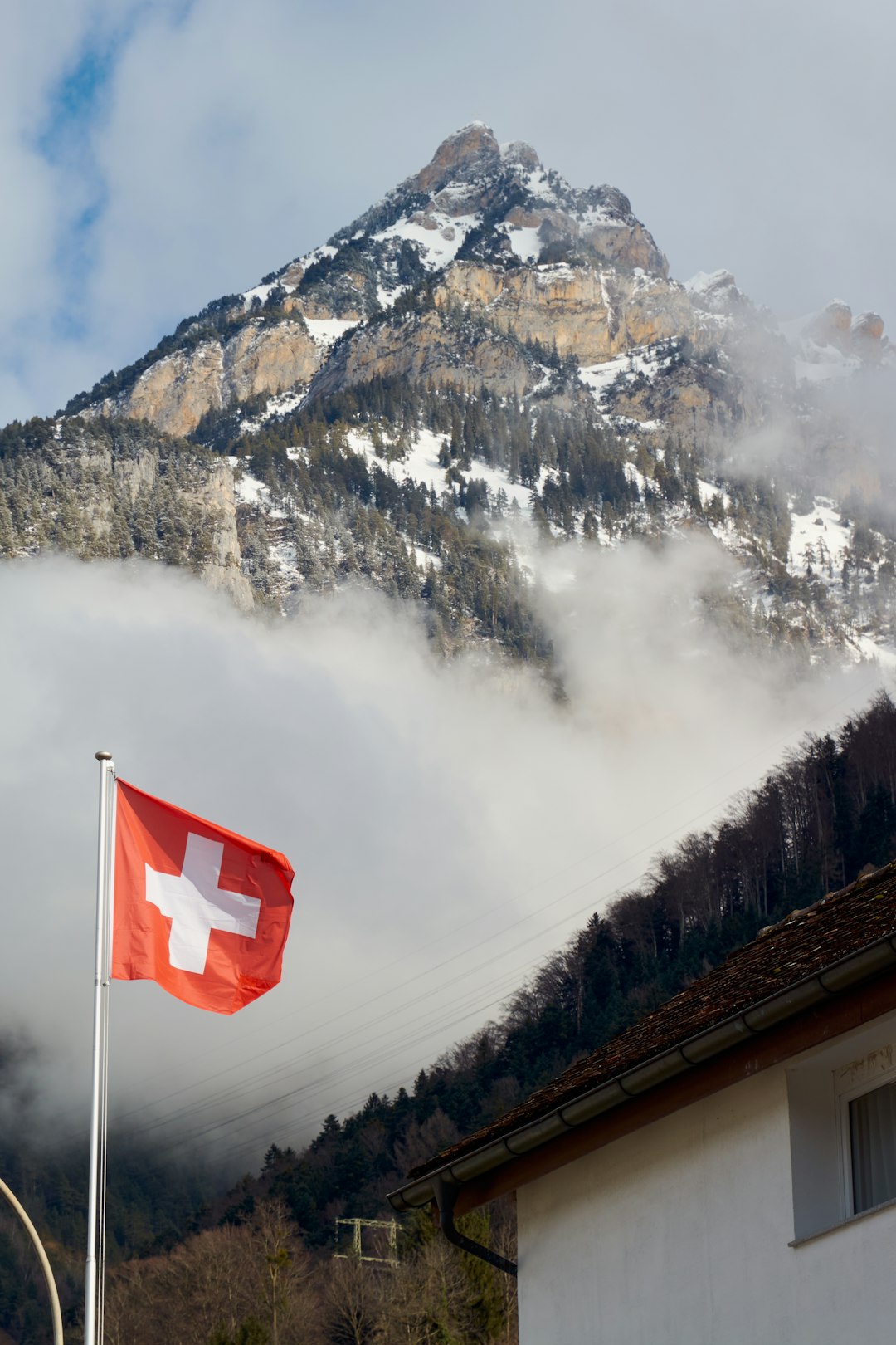 Bandiera svizzera con montagna innevata sullo sfondo, simbolo delle richieste dei docenti per il caldo record nelle scuole.