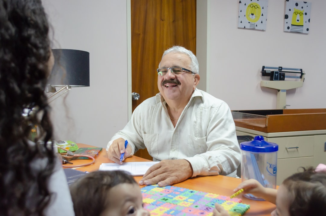 Visita medica pediatrica in ambulatorio scolastico, medico sorridente con bambini, salute nelle scuole e prevenzione