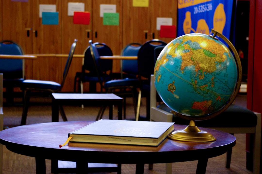 Globo geografico e libro su tavolo in aula scolastica. Iscrizioni gratuite per il personale ATA e prova finale.