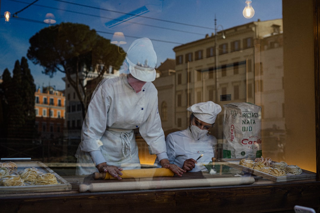 Cucina italiana patrimonio UNESCO: chef preparano pasta fresca a Roma, focus su alimentazione e tradizioni culinarie italiane.