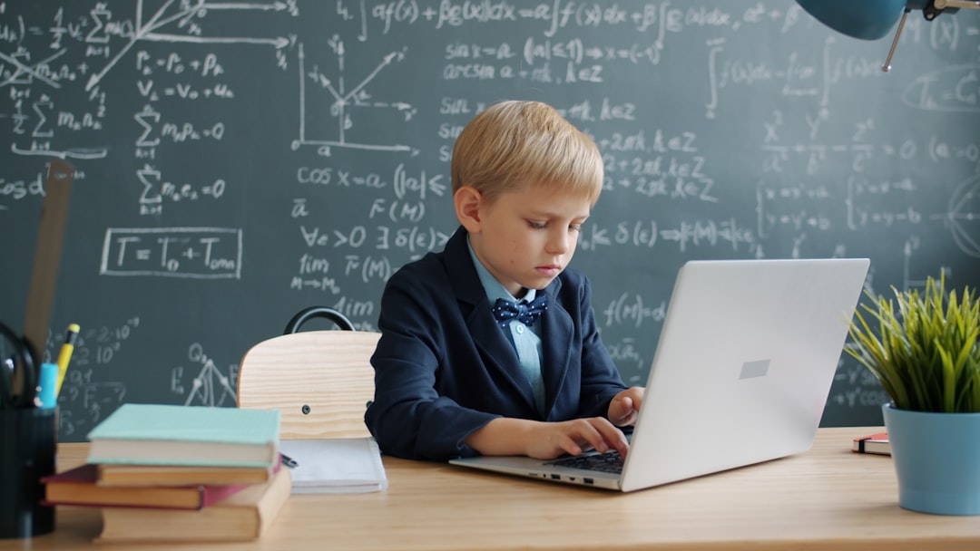 Bambino che usa l'intelligenza artificiale a scuola su un laptop, lavagna con formule matematiche sullo sfondo. Apprendimento AI