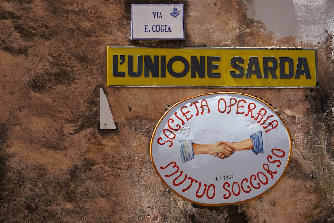 Insegna storica L'Unione Sarda e della Società Operaia Mutuo Soccorso in Sardegna, con riferimento a Via E. Cugia